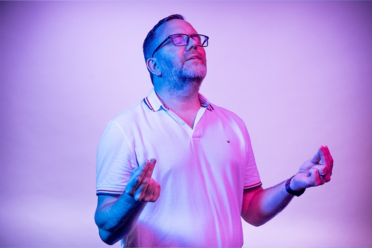 Mann hat Augen geschlossen und hält die Hände vor sich