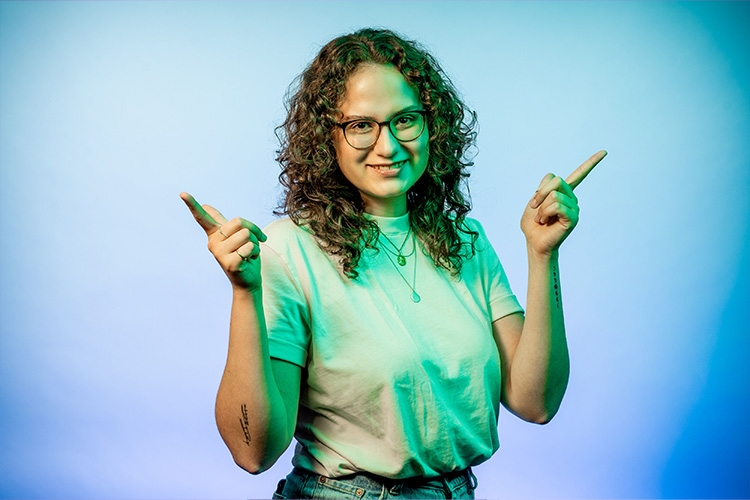 Frau hält Hände hoch und hat Zeigefinger abgespreizt